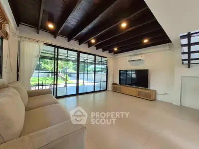 Spacious living room with modern design and large windows overlooking garden.