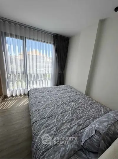 Bright bedroom with large windows and modern decor, perfect for relaxation and comfort.