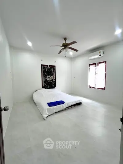 Spacious minimalist bedroom with ceiling fan and air conditioning