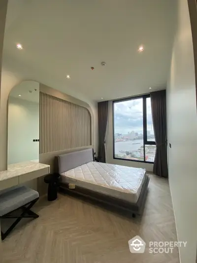 Modern bedroom with large window offering stunning city view