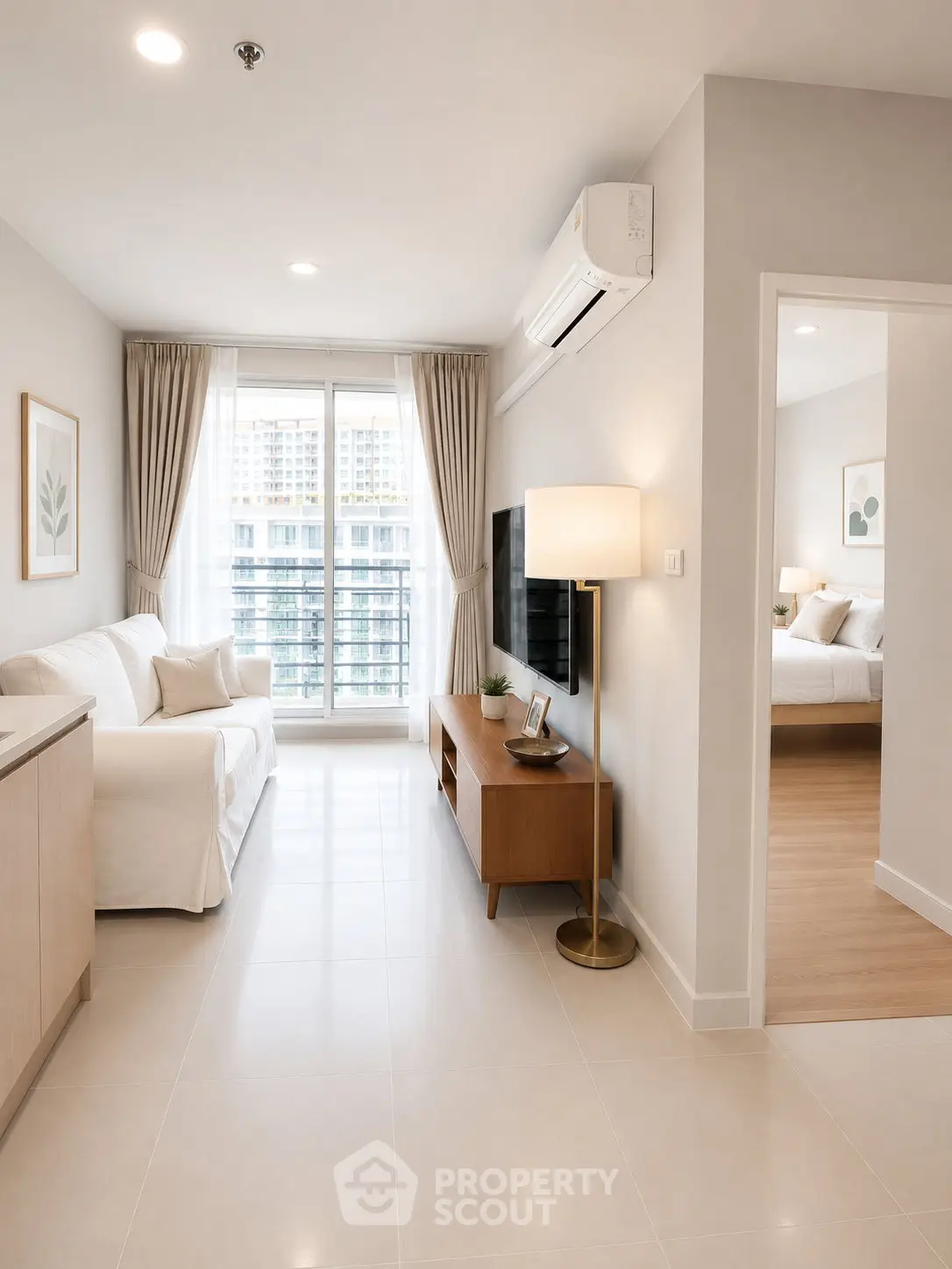 Modern living room with natural light, stylish furniture, and a glimpse into a cozy bedroom.