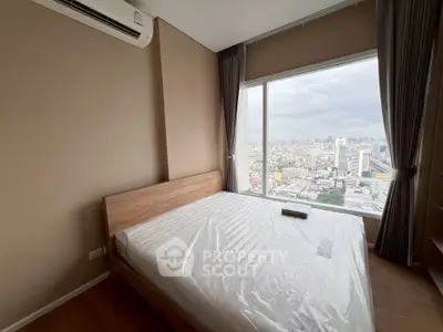Modern bedroom with large window offering stunning city view