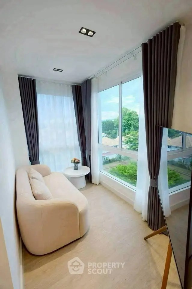 Bright and cozy corner unit with large windows and scenic view, perfect for relaxation.