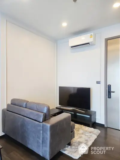 Modern living room with sleek furniture and wall-mounted air conditioner