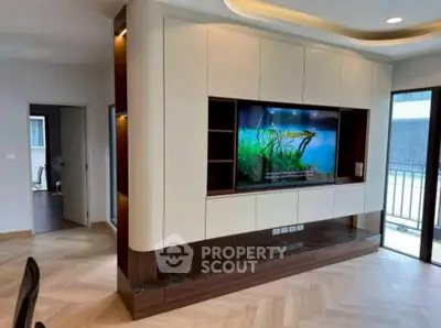 Modern living room with built-in entertainment center and balcony view