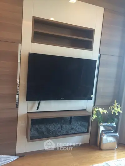 Modern living room with sleek TV setup and stylish wooden paneling