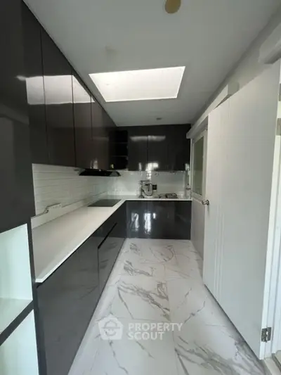 Modern kitchen with sleek black cabinets and marble flooring