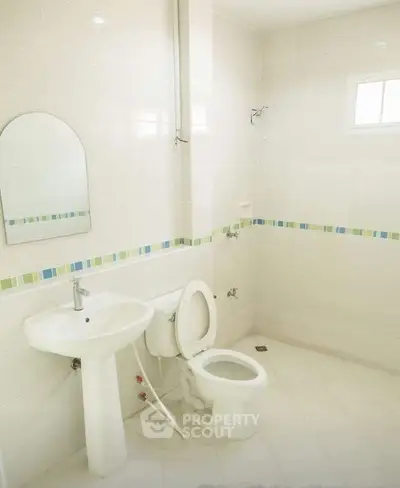 Bright and clean bathroom with modern fixtures and colorful tile accents.