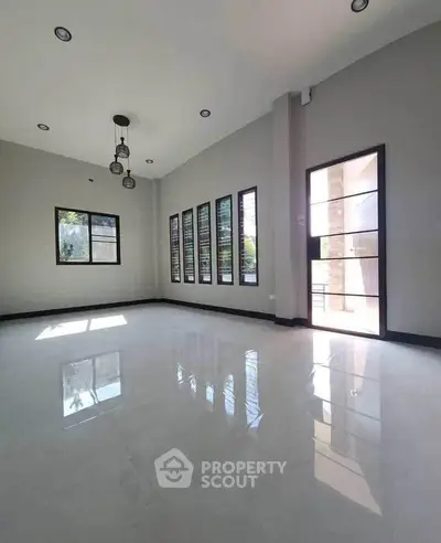 Spacious modern living room with large windows and high ceiling