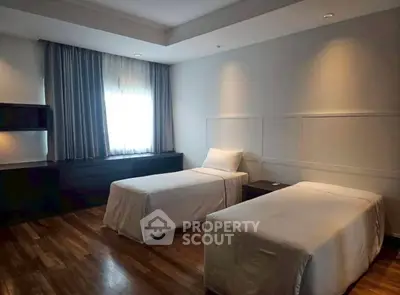 Spacious bedroom with twin beds and elegant wooden flooring