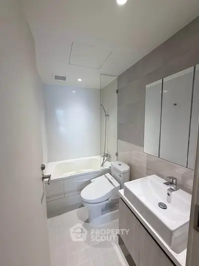 Modern bathroom with sleek fixtures and bathtub in contemporary apartment.