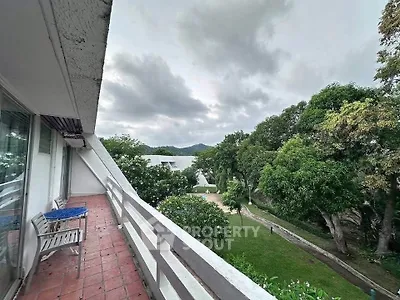 Spacious balcony with scenic garden view in a serene residential area.