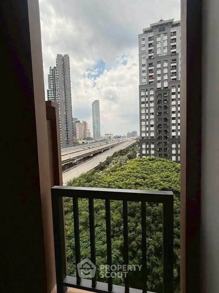 Stunning cityscape view from a high-rise balcony overlooking lush greenery and modern skyscrapers.