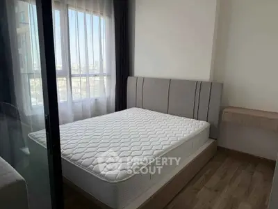 Modern bedroom with large window and stylish headboard in a bright apartment.