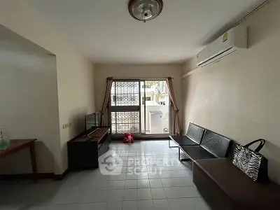 Spacious living room with air conditioning and large window for natural light.