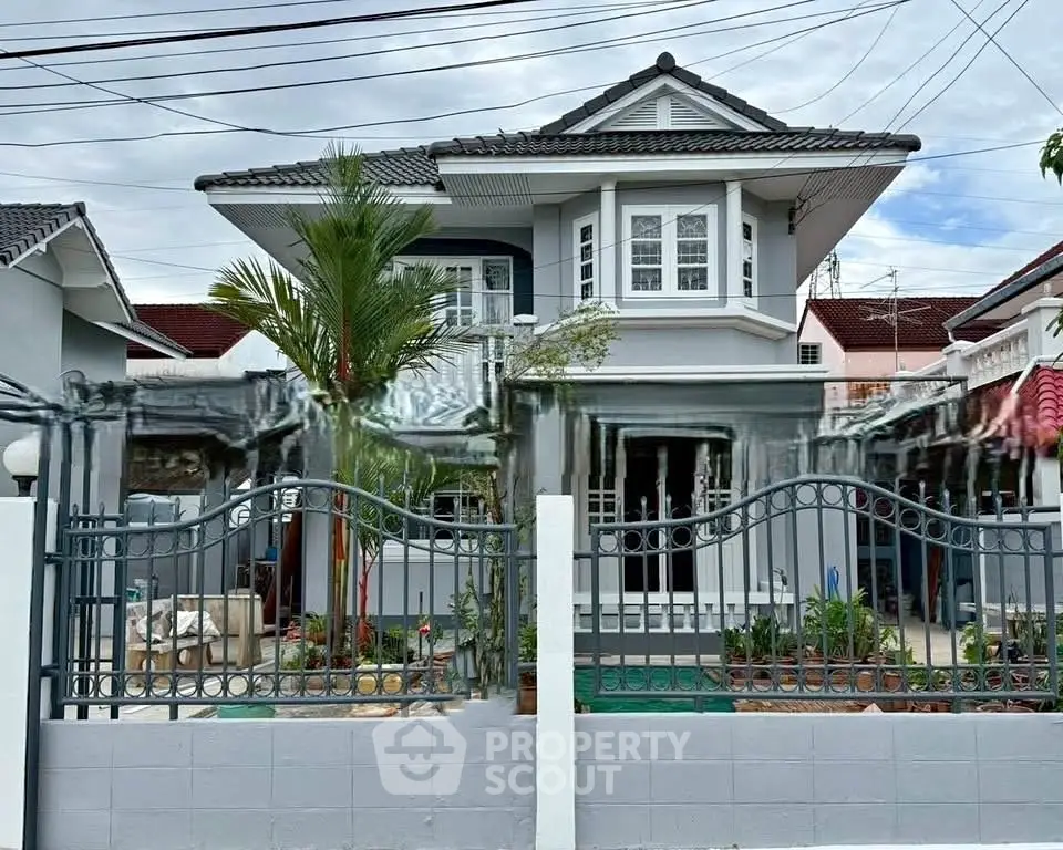 Charming two-story house with elegant facade and lush garden in a serene neighborhood.