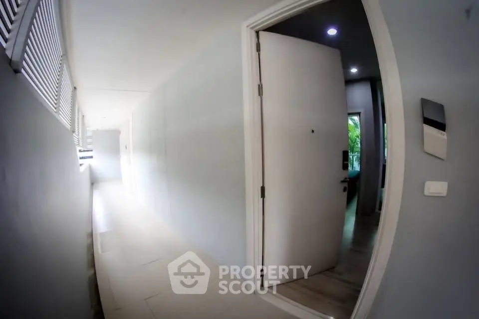 Modern apartment entrance with open door and hallway view