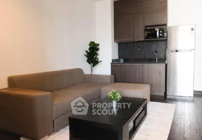 Modern living room with cozy sofa, sleek kitchenette, and stylish decor in a contemporary apartment.