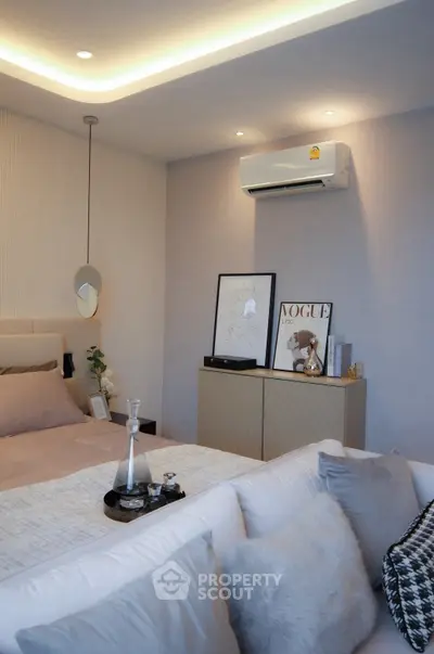 Elegant bedroom with modern decor and cozy ambiance, featuring stylish lighting and air conditioning.