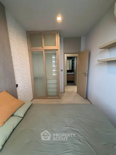 Modern bedroom with stylish wardrobe and cozy bedding in a contemporary apartment.