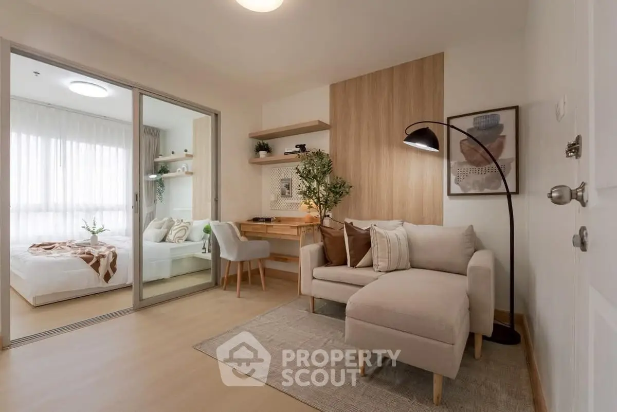 Modern living room with cozy sofa and stylish decor adjacent to a bright bedroom.