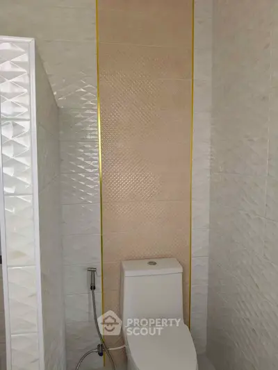 Modern bathroom with stylish tile design and sleek toilet fixture.