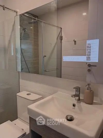 Modern bathroom with glass shower and sleek fixtures in a contemporary apartment.