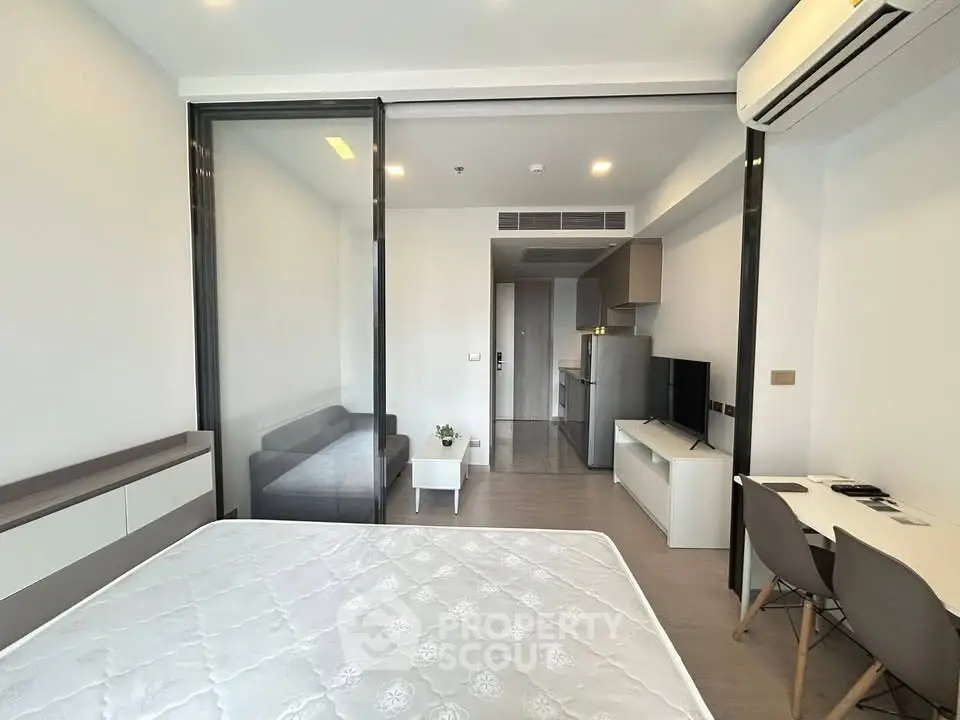 Modern studio apartment with open layout, featuring a cozy living area and sleek kitchen.