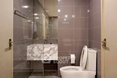 Modern bathroom with sleek marble sink and glass shower enclosure