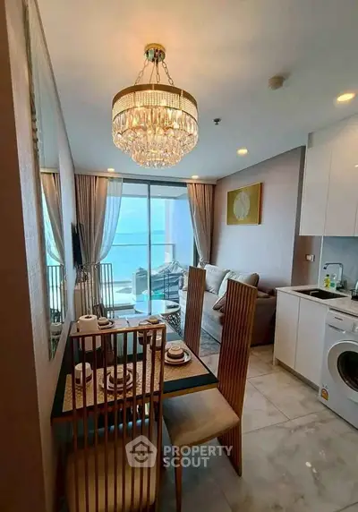 Luxurious living room with elegant chandelier and ocean view balcony in modern apartment