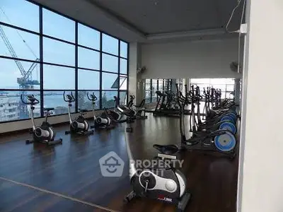 Spacious gym with modern equipment and panoramic city views.