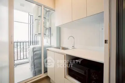 Modern kitchen with sleek cabinetry and balcony view