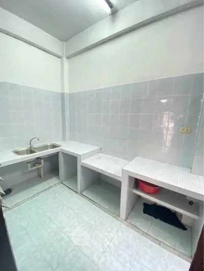 Spacious tiled kitchen with open shelving and stainless steel sink, ideal for modern living.