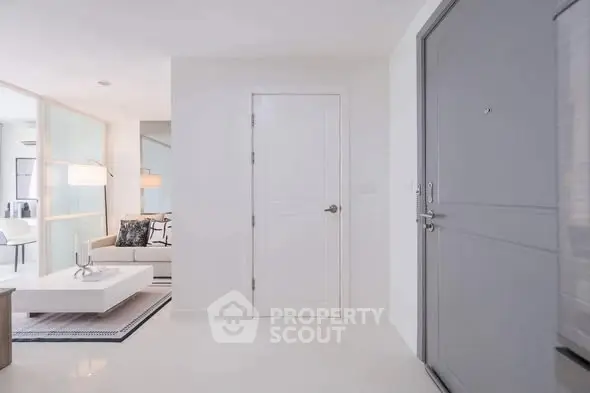 Modern apartment entrance with sleek white interior and cozy living area