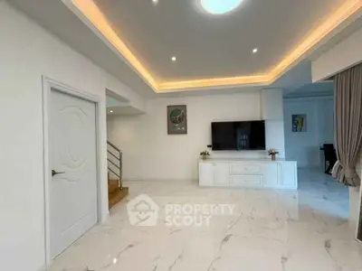 Spacious modern living room with elegant lighting and sleek marble flooring.