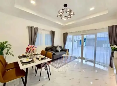 Modern living room with elegant decor and dining area, featuring large windows and stylish lighting.