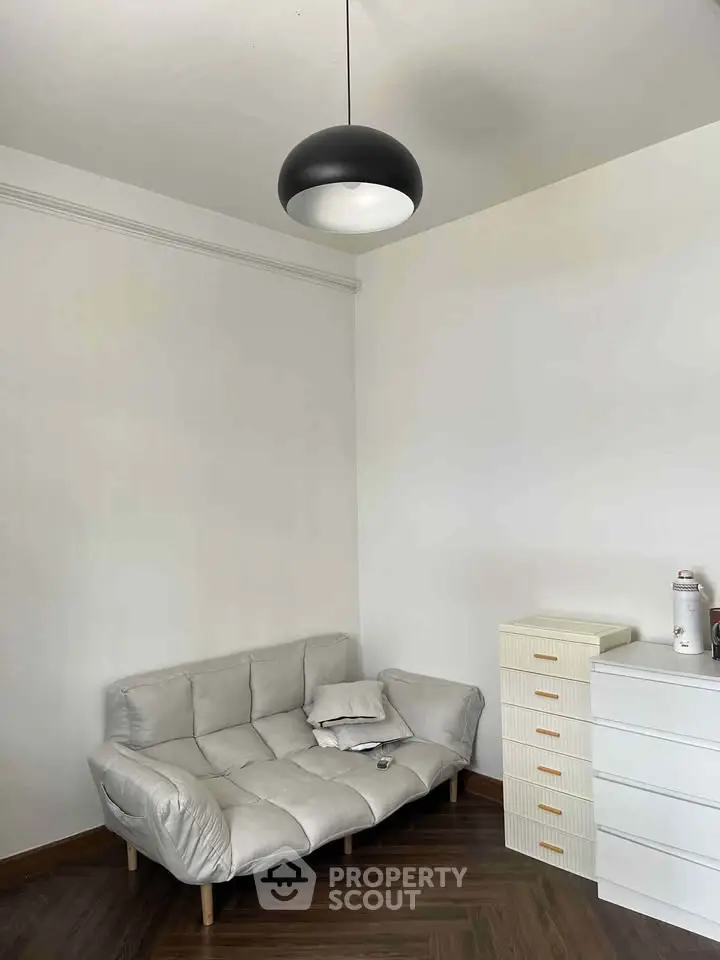 Cozy minimalist living room with modern lighting and sleek furniture.