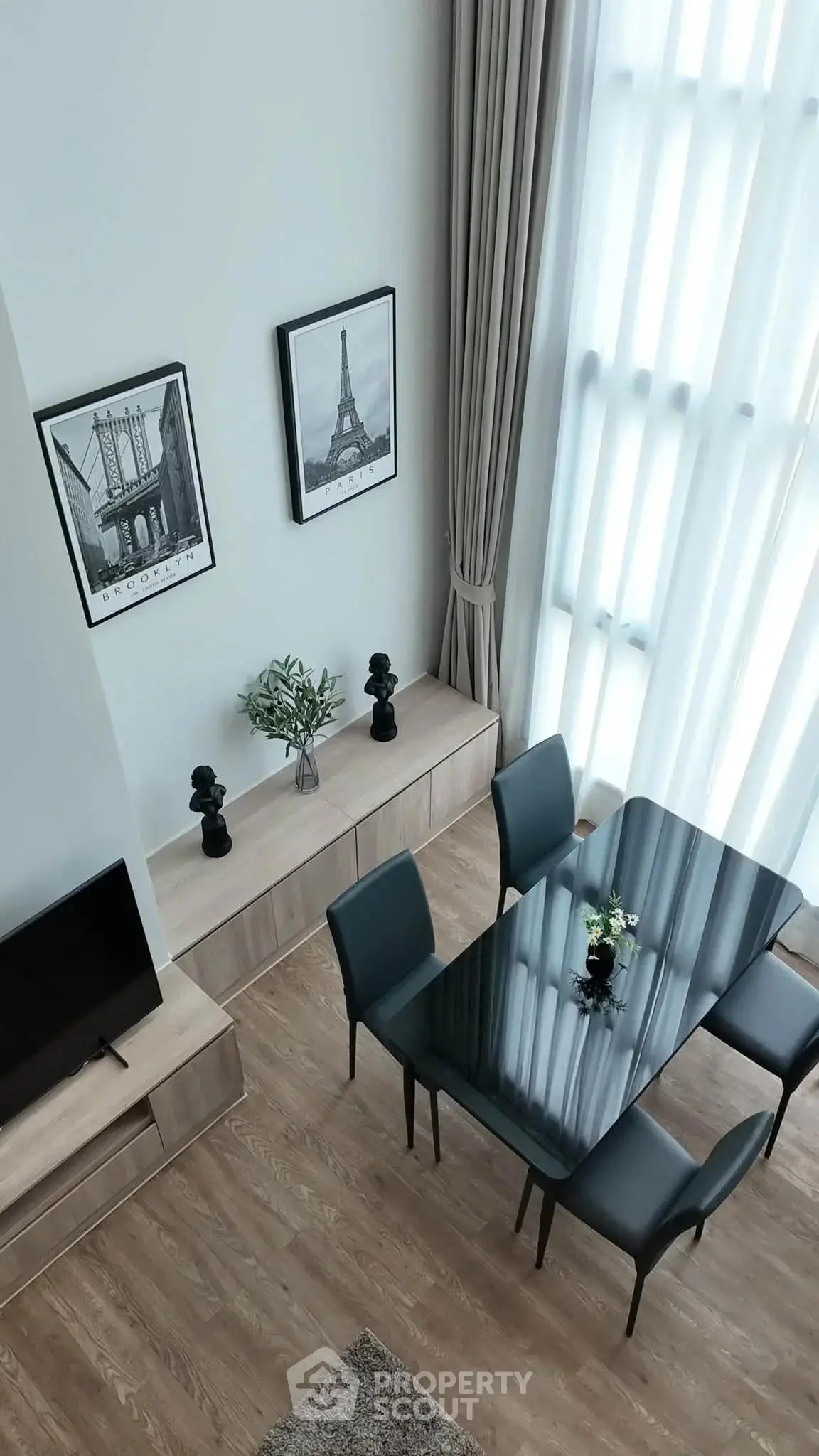 Elegant modern dining area with high ceilings and stylish decor in a contemporary apartment.