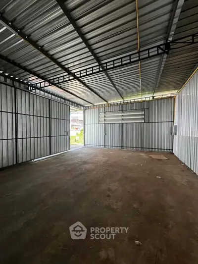 Spacious metal-walled storage unit with ample natural light and secure structure.