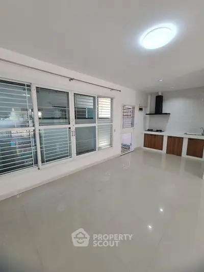 Spacious modern kitchen with sleek design and large windows for natural light.