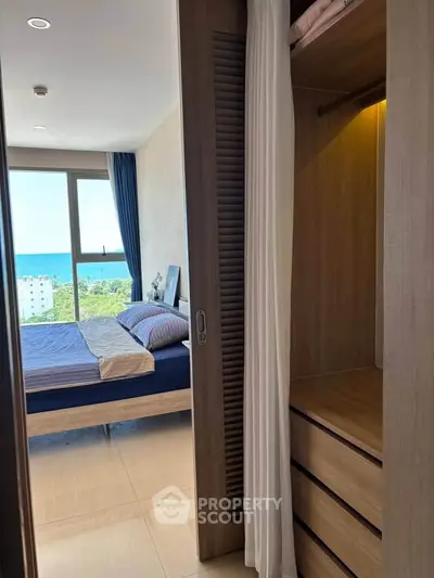 Stunning bedroom with ocean view and built-in closet in modern apartment.