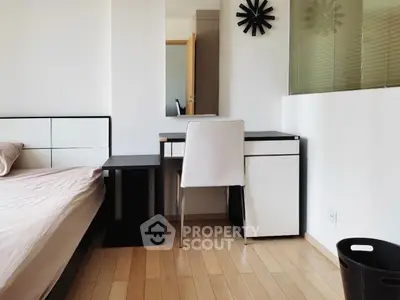 Modern bedroom with sleek furniture and minimalist design, featuring a study desk and comfortable chair.