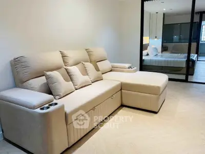 Modern living room with beige sectional sofa and view into stylish bedroom