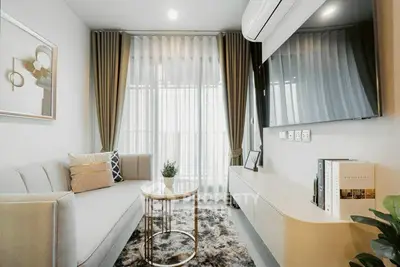 Modern living room with stylish decor, large TV, and elegant furniture.