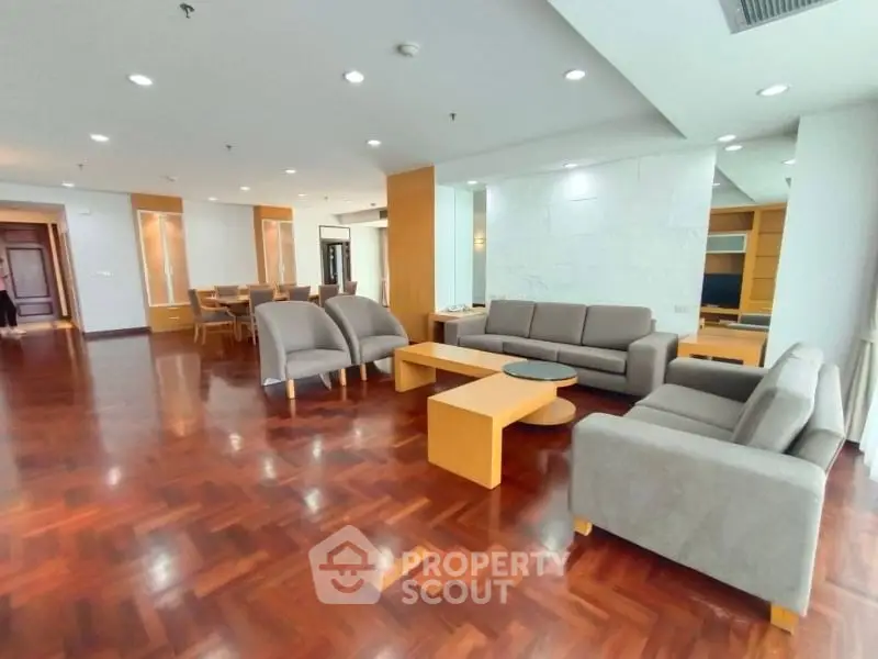 Spacious modern living room with elegant wooden flooring and stylish furniture.