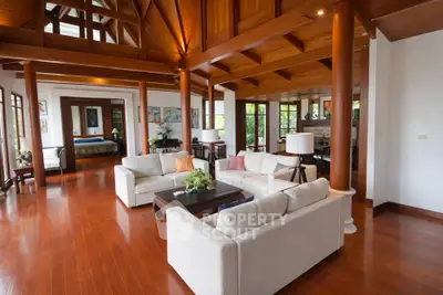 Spacious open-plan living room with wooden ceiling and elegant furnishings in a luxury home.