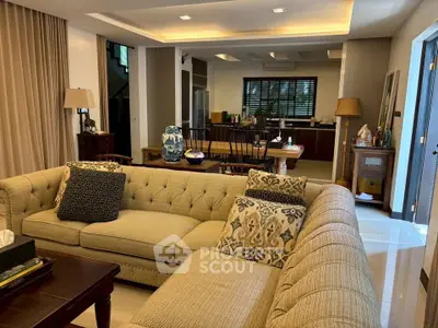 Spacious living room with elegant decor and open layout leading to dining area and kitchen.