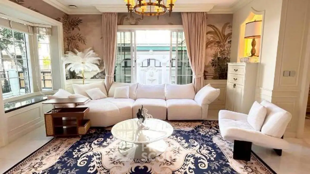Luxurious living room with elegant white furniture and large windows, perfect for relaxation and entertaining.