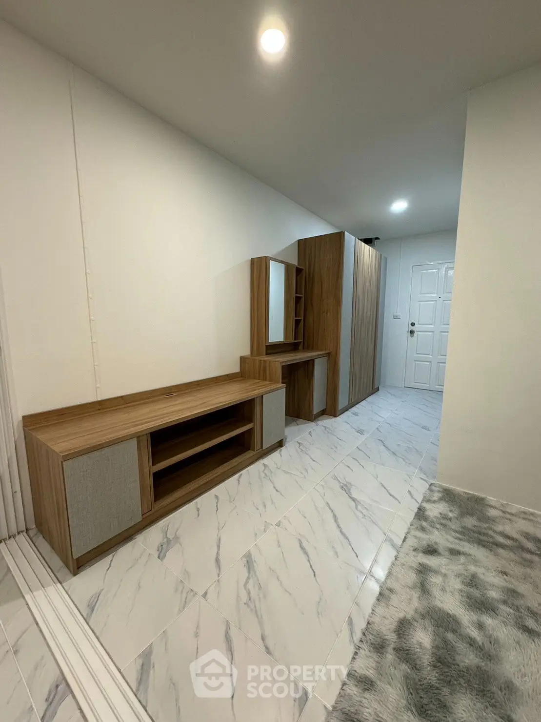 Modern interior hallway with stylish wooden furniture and marble flooring