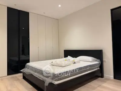 Modern bedroom with sleek black bed frame and spacious wardrobe